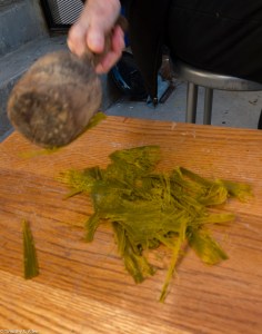 Beating fan palm leaves after cooking and wasshing